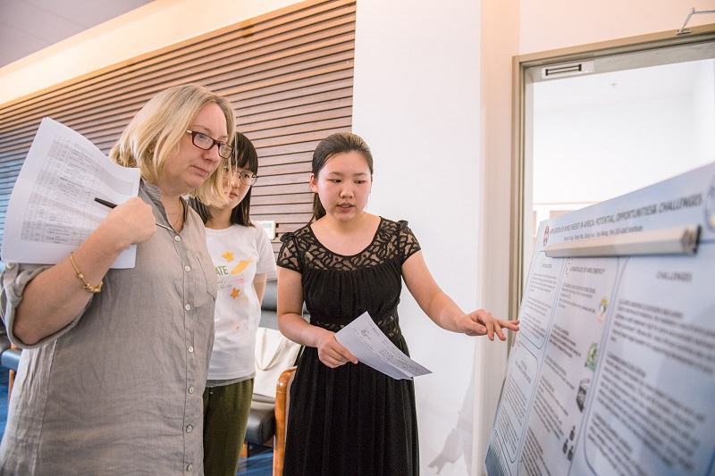 Students showing their poster to Prof Sue