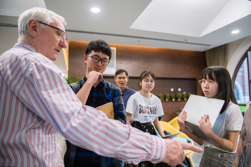 Professor discussing a poster with a student